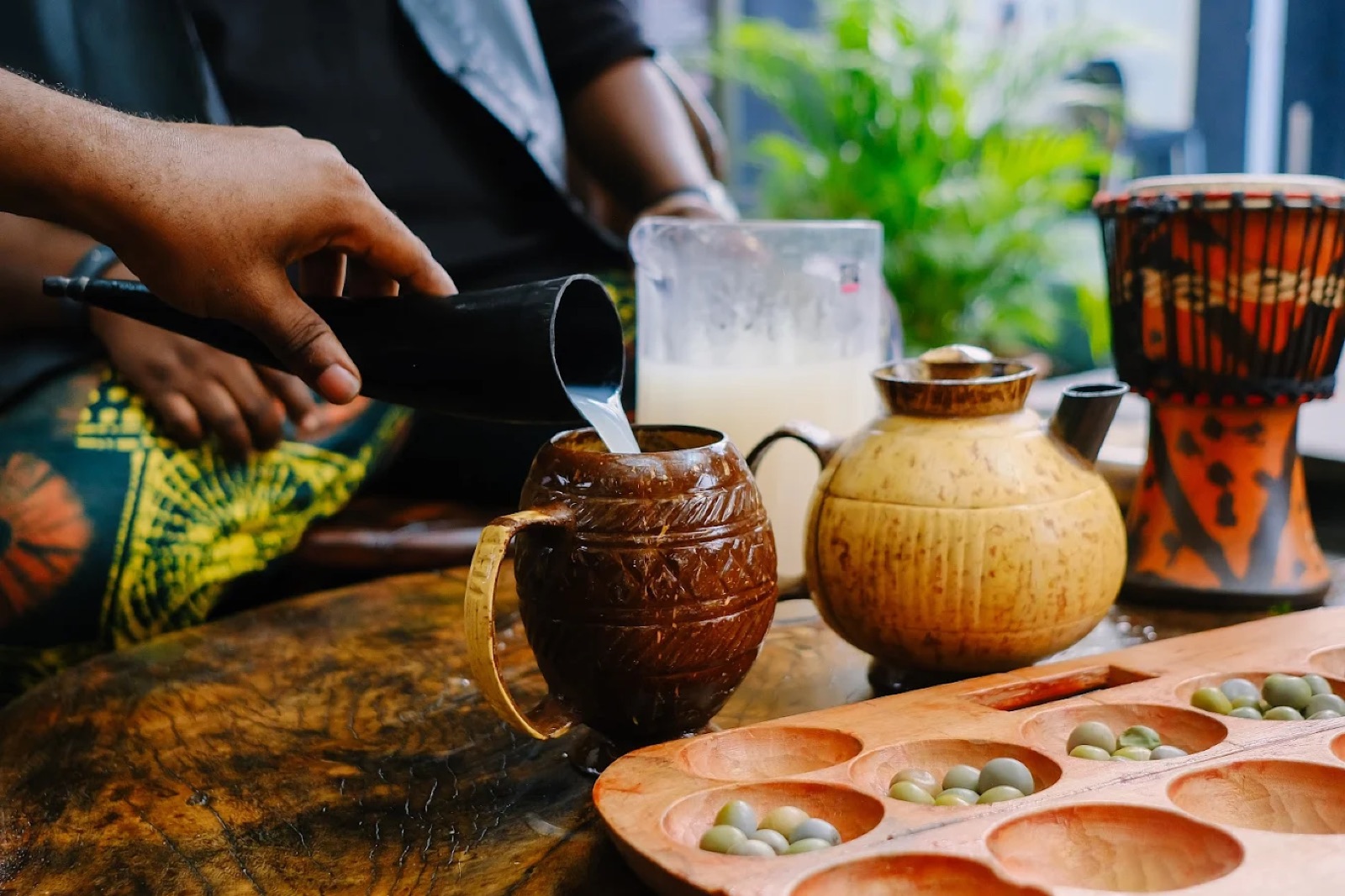 Palm wine being poured into a wooden cup at Kulture Yard
